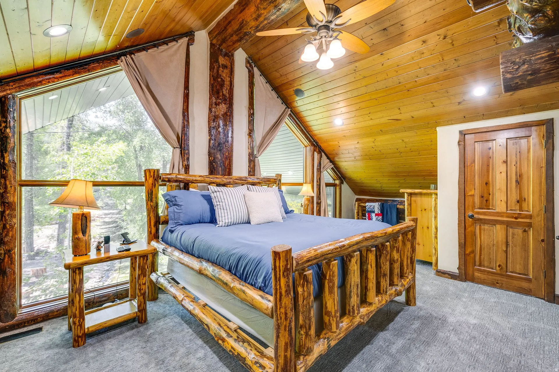 Room featuring a wood-paneled sloped ceiling, wood-finish flooring, and expansive windows
