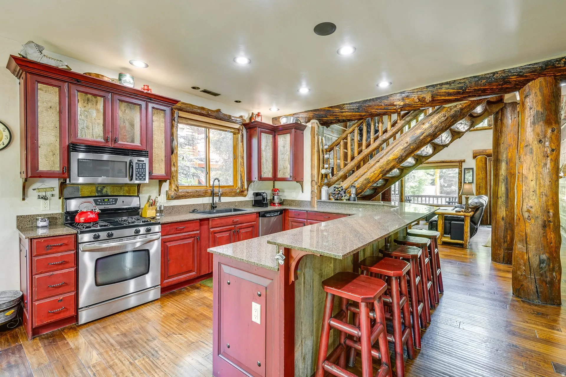 Kitchen featuring red cabinetry, stainless steel appliances, and granite countertops