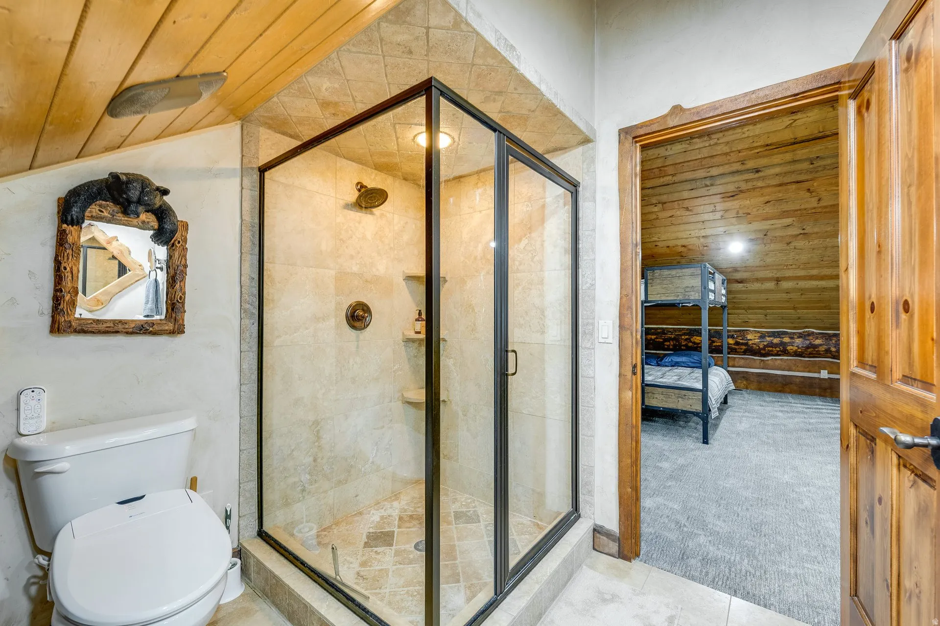Glass-enclosed shower with tiled walls and floor