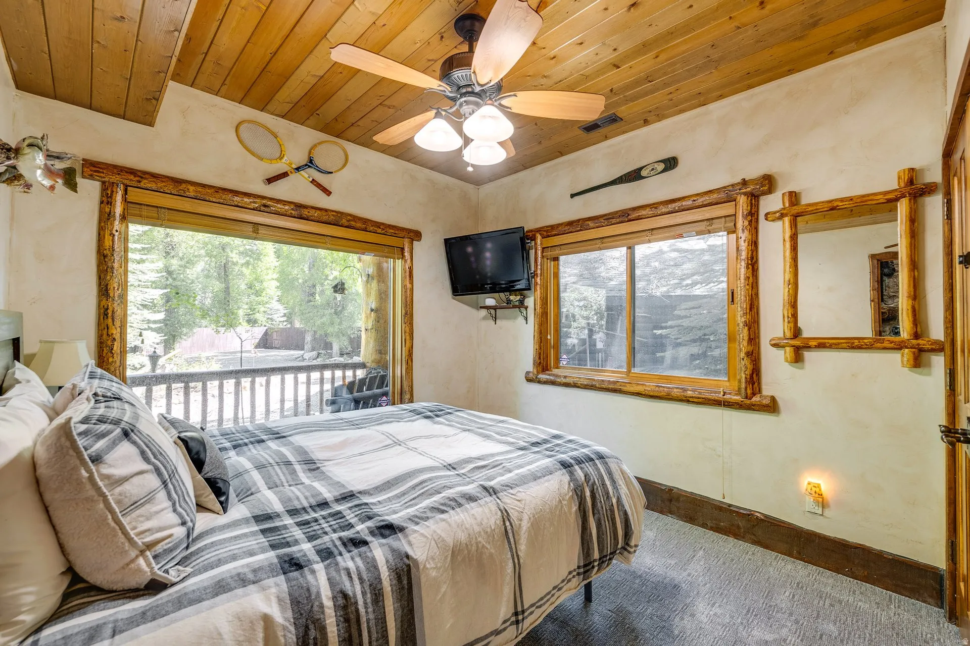 Bedroom featuring a wood-paneled ceiling, ceiling fan, and wood-trim windows