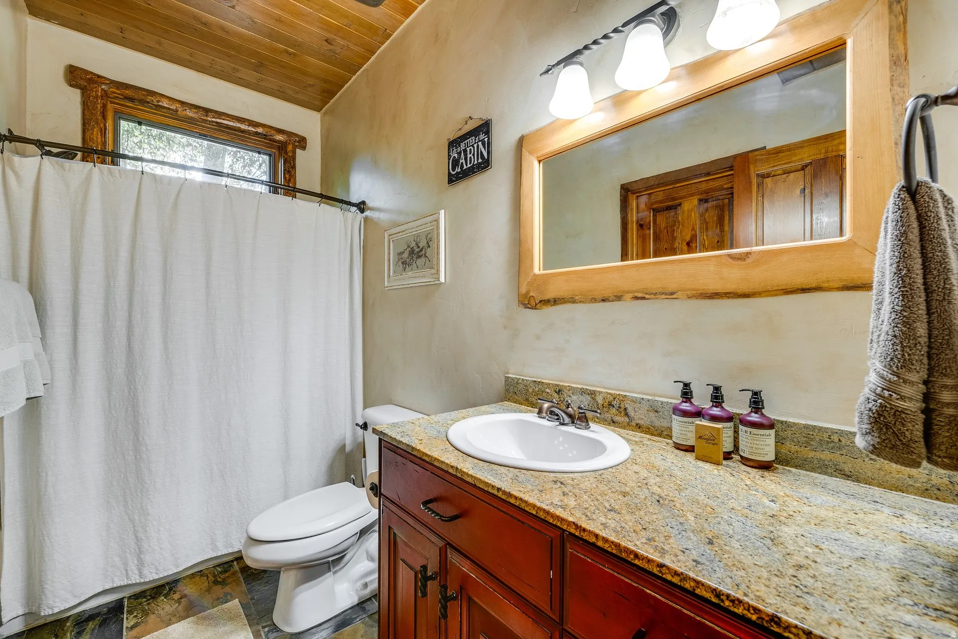 Granite-style countertop with an integrated sink and a wood-framed mirror