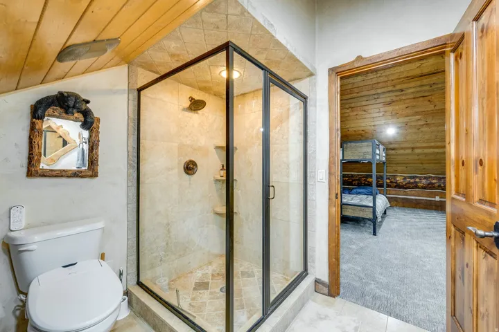 Glass-enclosed shower with tiled walls and floor