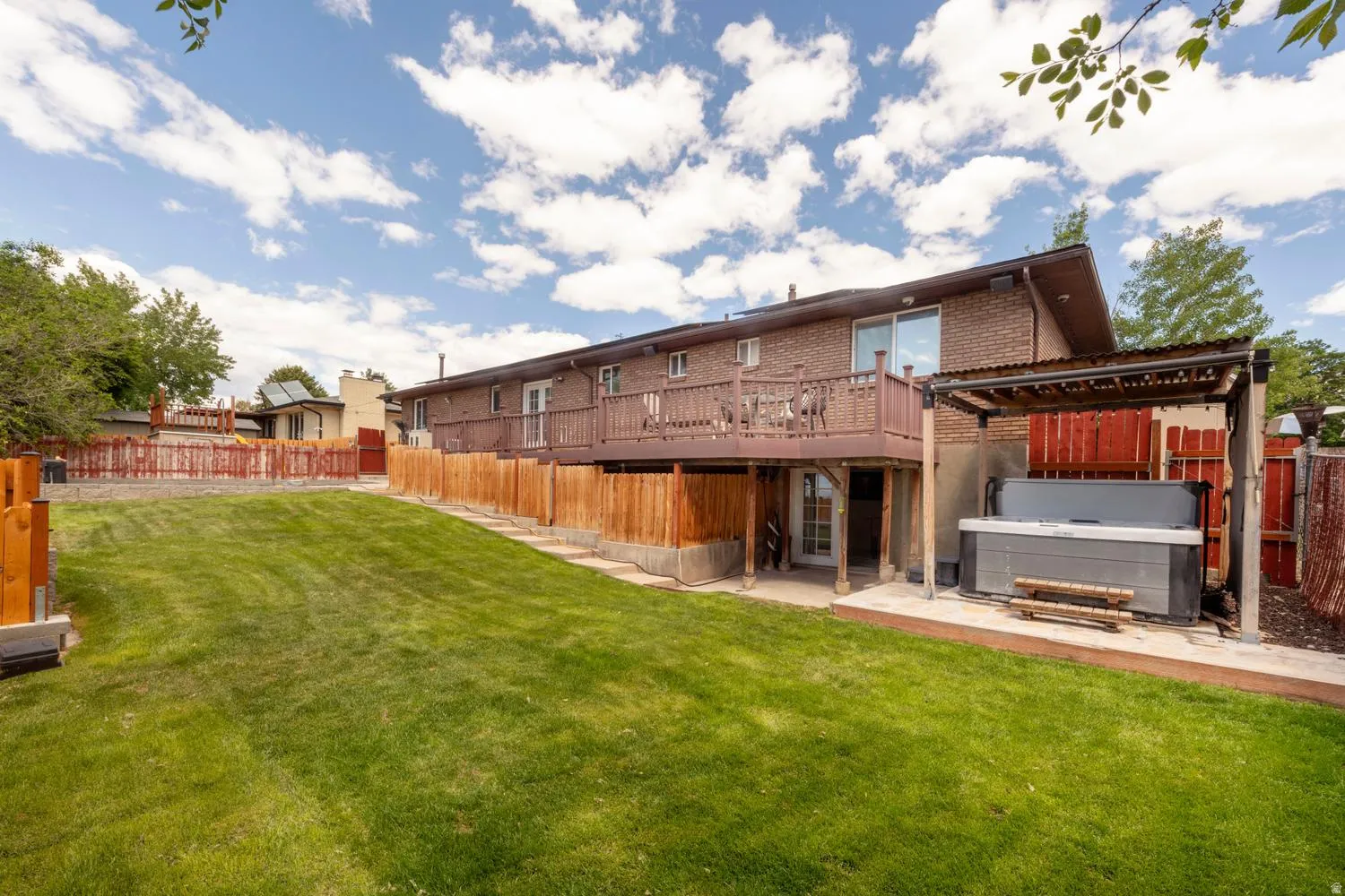 Expansive green lawn with a full wooden privacy fence