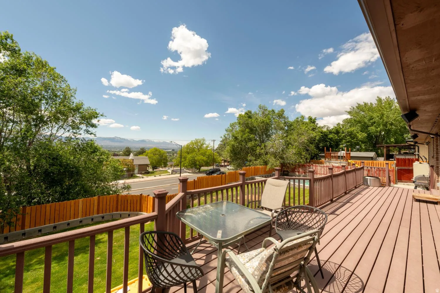 Expansive outdoor deck featuring wood-finish flooring and a full-height wooden railing system