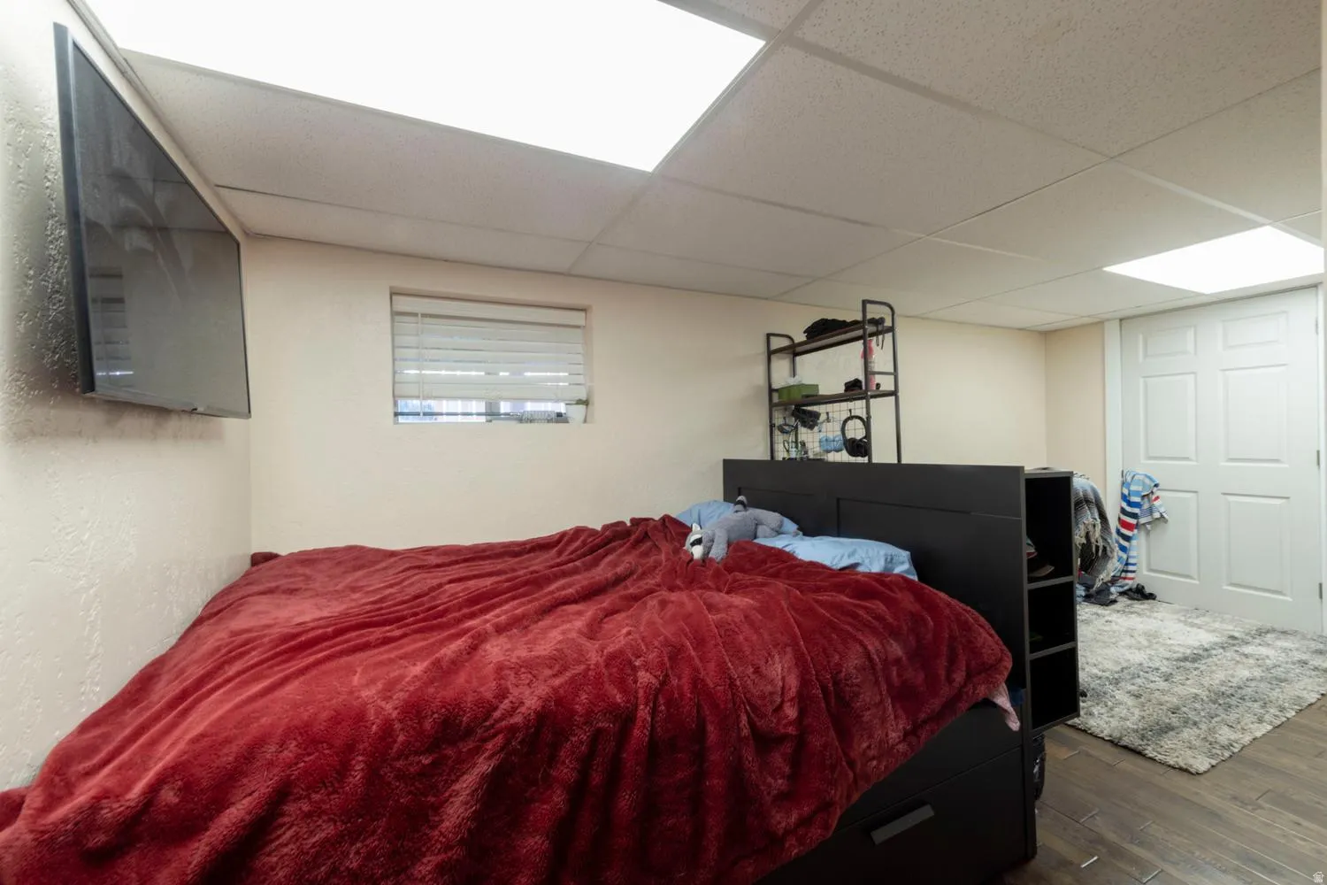 Interior room featuring wood-finish flooring and a drop ceiling with integrated lighting
