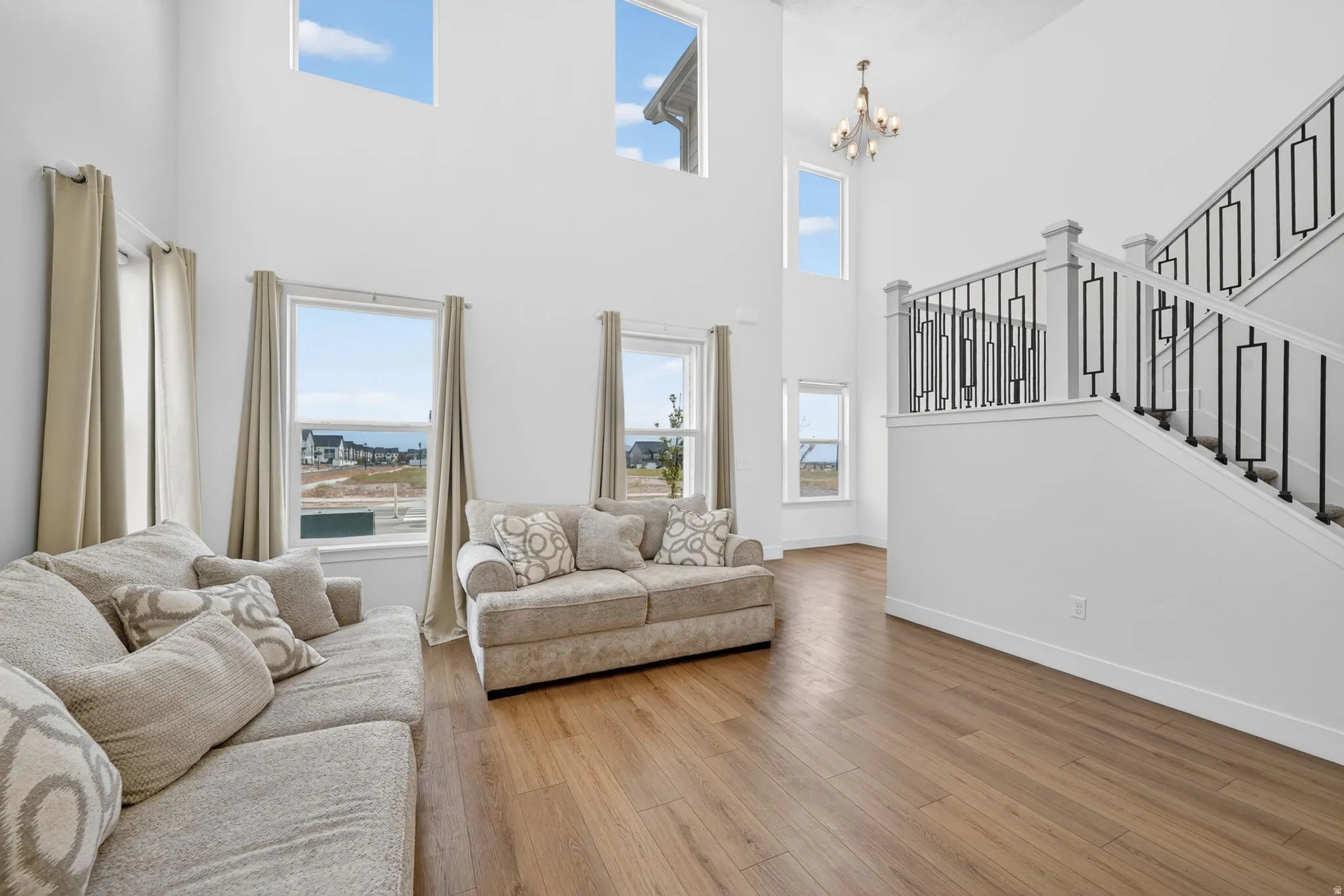 Two-story living area featuring a prominent staircase with black metal balusters and white risers