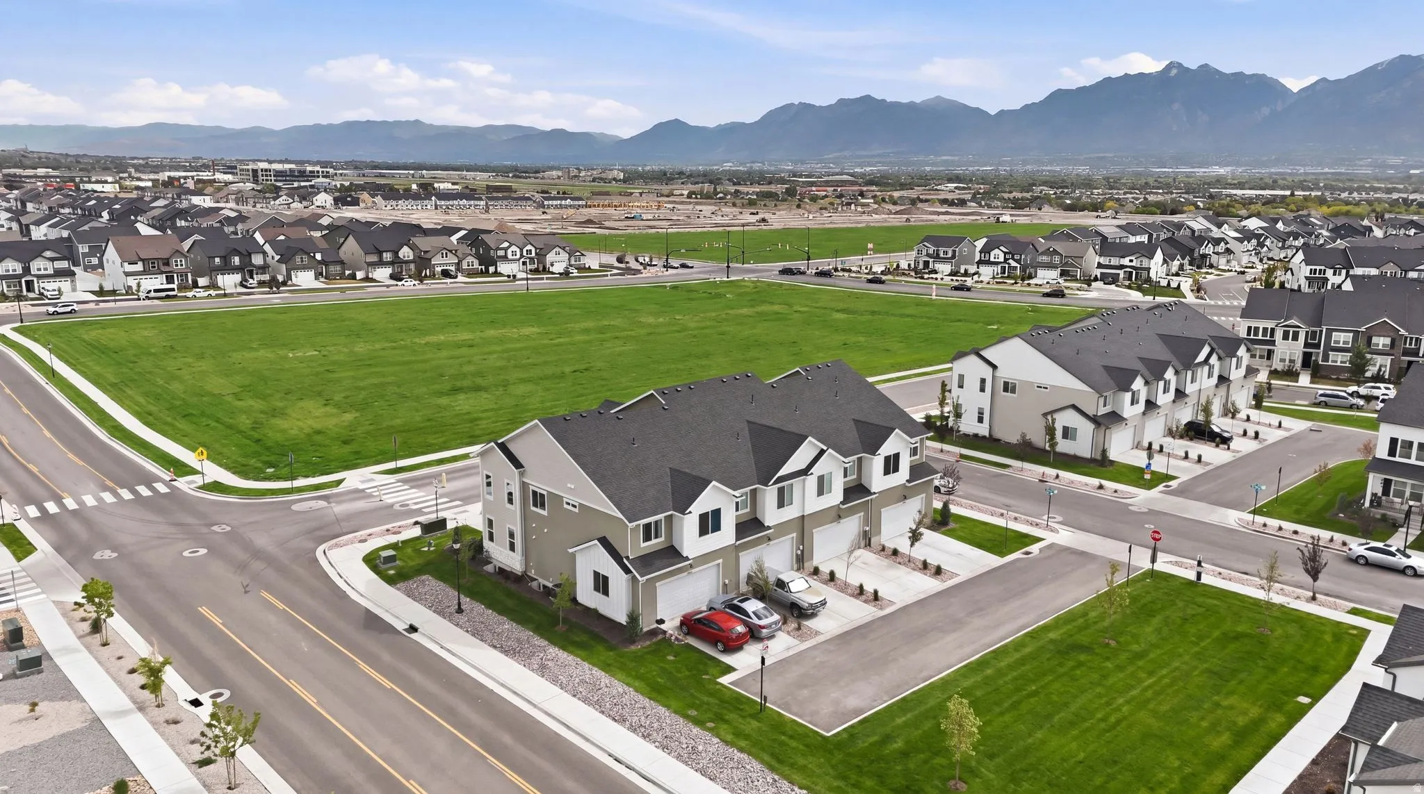 Newly constructed townhome with a dark shingle roof, light-toned siding, and white trim accents