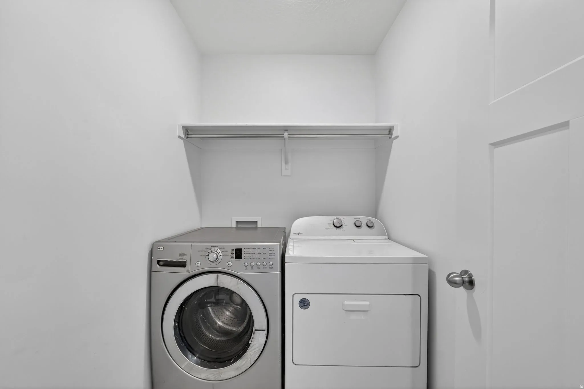 Dedicated laundry area featuring a built-in shelf and hanging rod