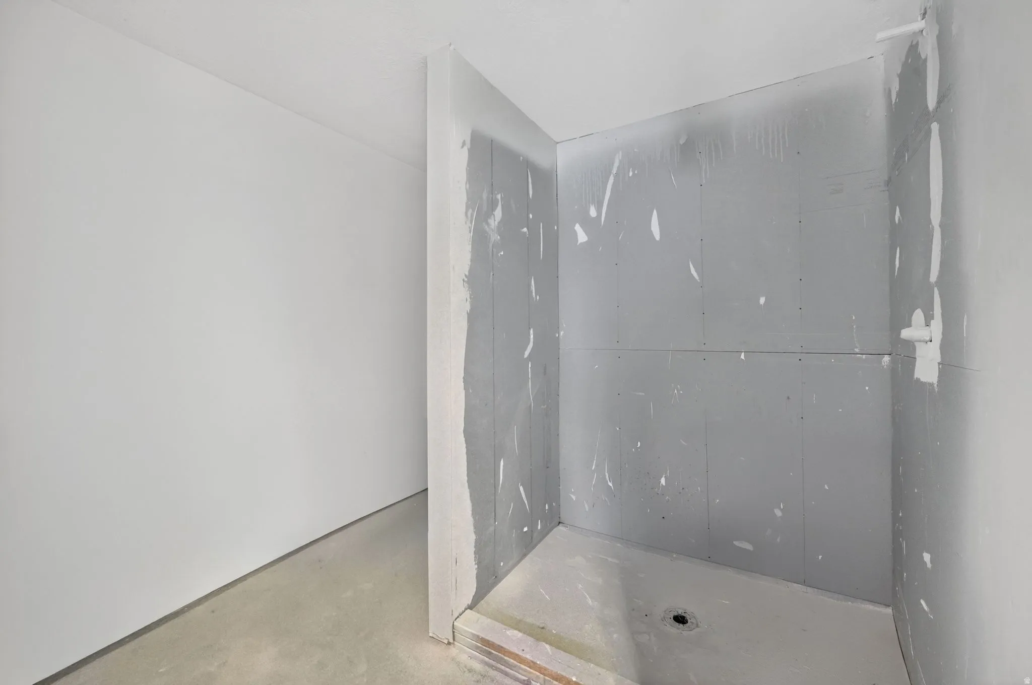 Shower enclosure with visible plumbing rough-in