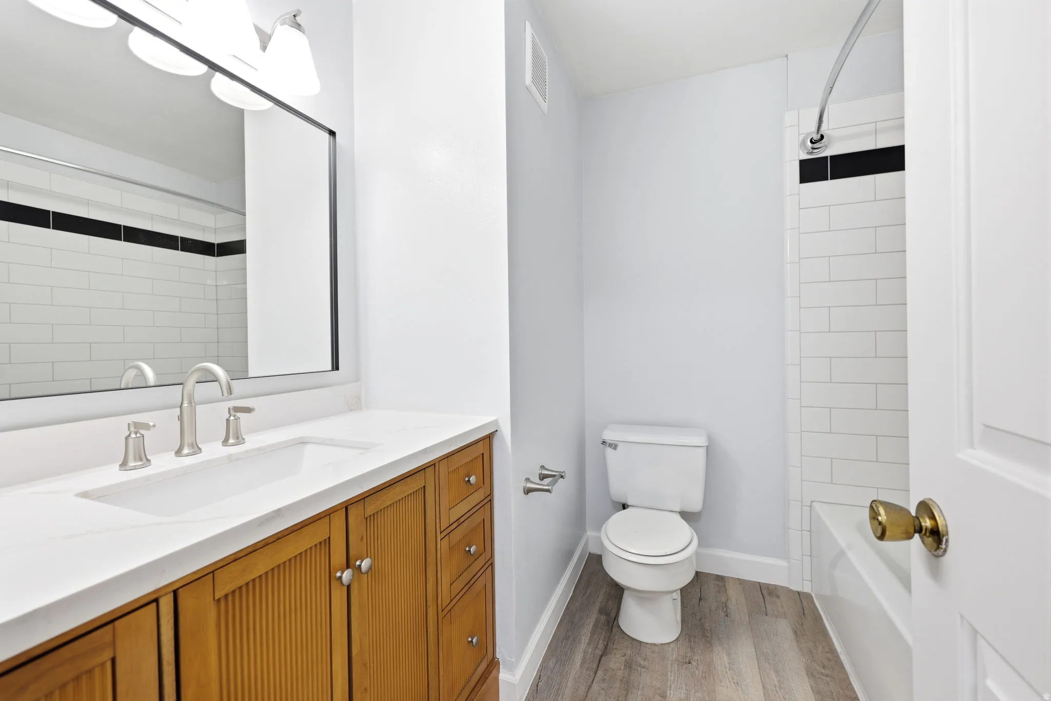 Bathroom featuring a wood-finish vanity with a white countertop and undermount sink
