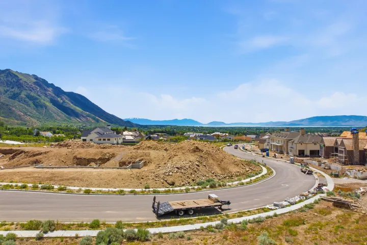 Curved paved road with concrete sidewalks and a mountain backdrop