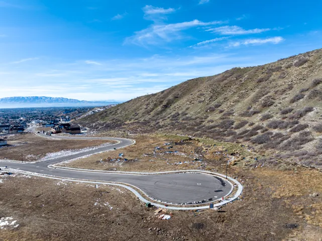 Paved cul-de-sac with concrete curbing, bordered by natural terrain