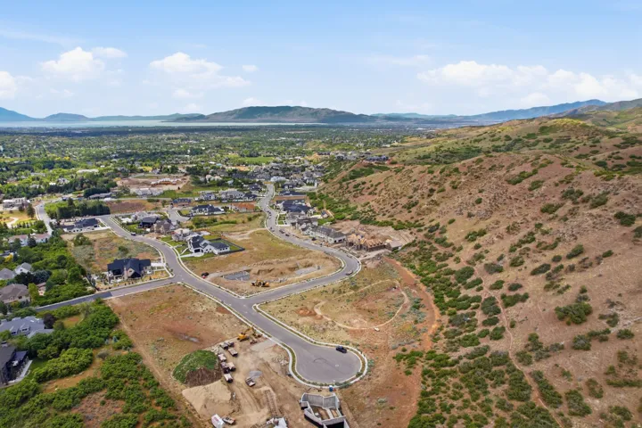 Expansive aerial perspective showcasing a developing residential community with existing homes and vacant lots