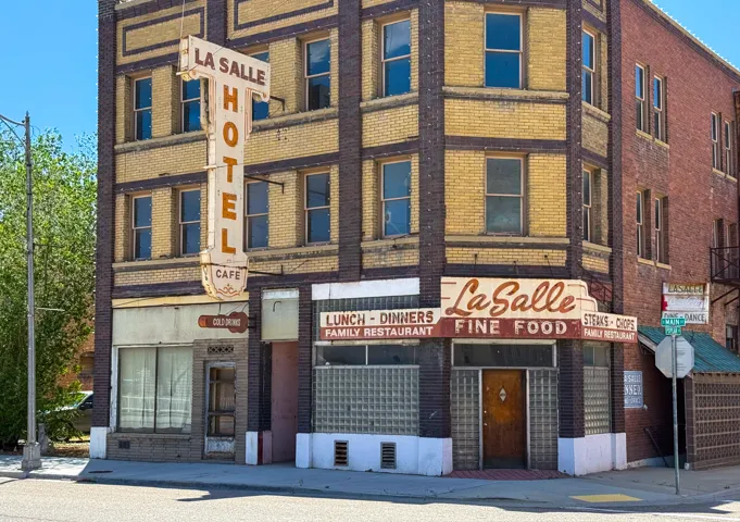 Historic commercial building featuring an intricate brick facade with decorative banding, multiple window units, and prominent vintage signage