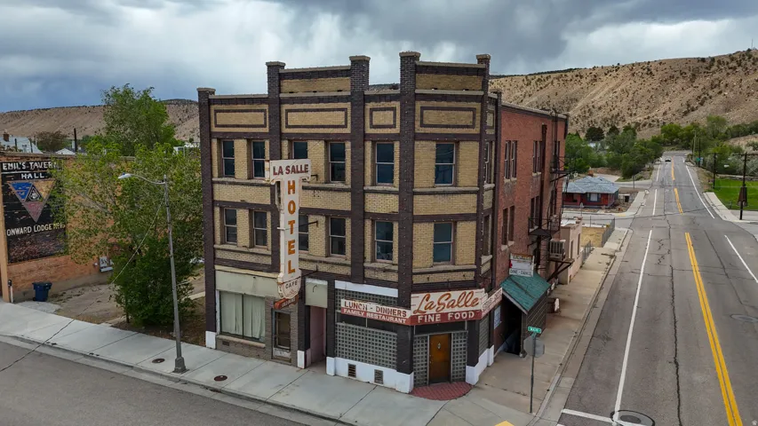 Three-story brick and masonry building featuring multiple windows and a street-level commercial storefront