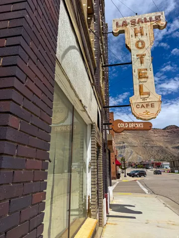 Brick facade building featuring a large storefront window and an illuminated sign