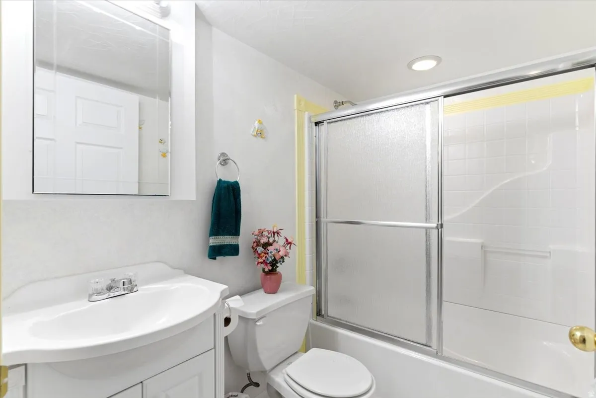Bathroom featuring a white vanity with integrated sink, chrome faucet, and a wall-mounted medicine cabinet