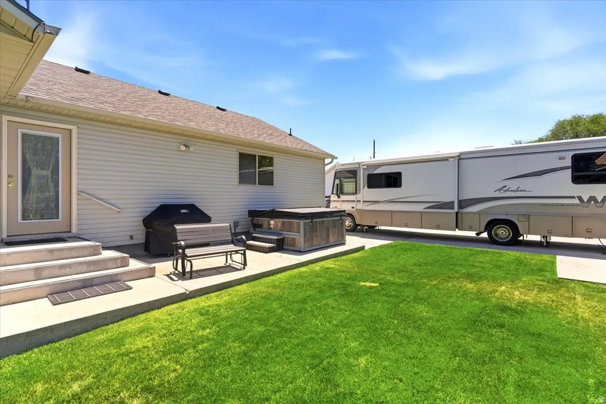 Expansive concrete patio with integrated spa, offering direct access to the interior