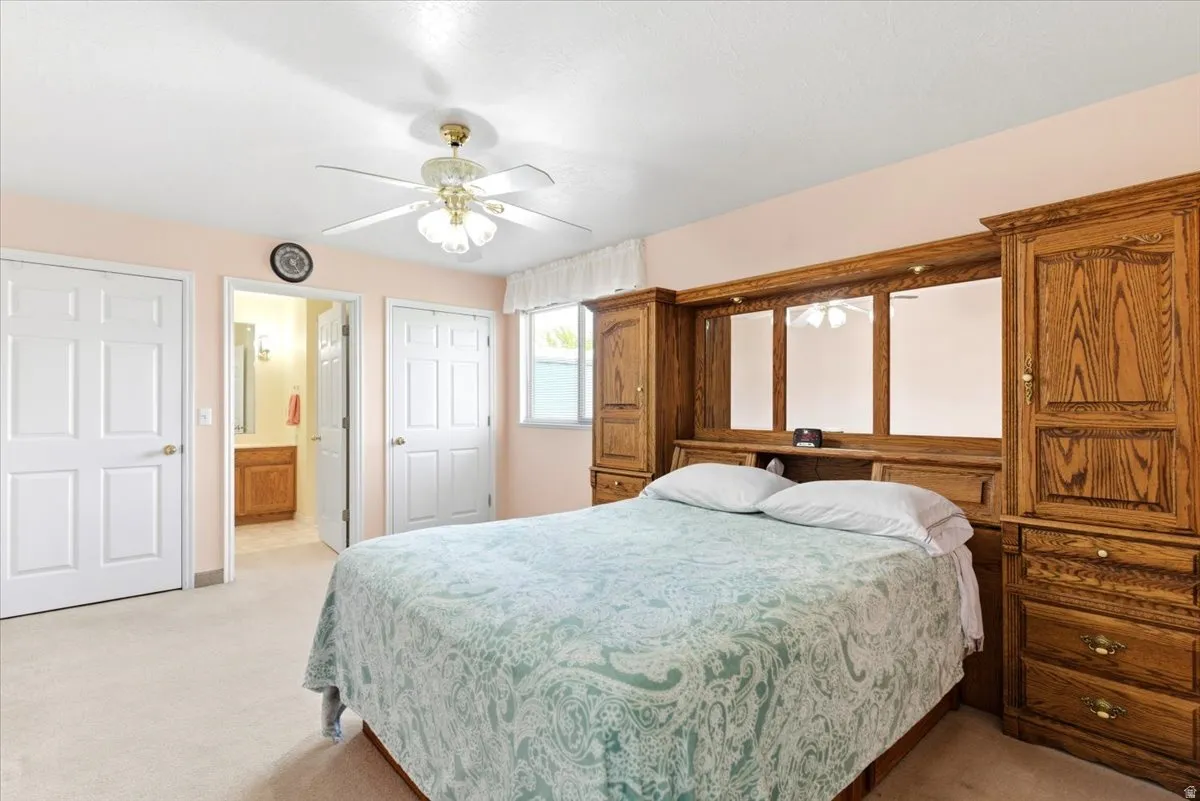 Bedroom featuring a built-in wood-finish wall unit with integrated mirrors