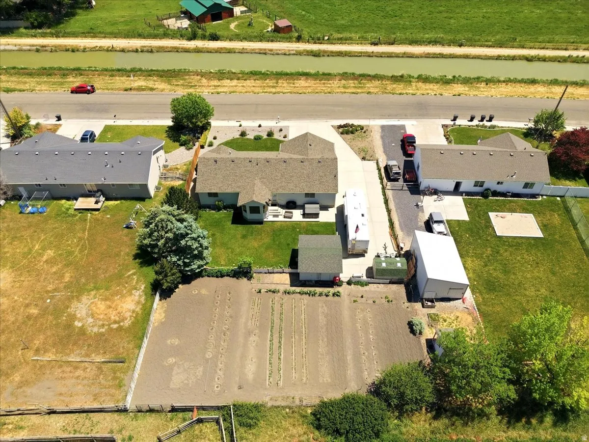 Aerial perspective showcasing a property with a cultivated garden plot, a separate outbuilding structure, and a secondary shed