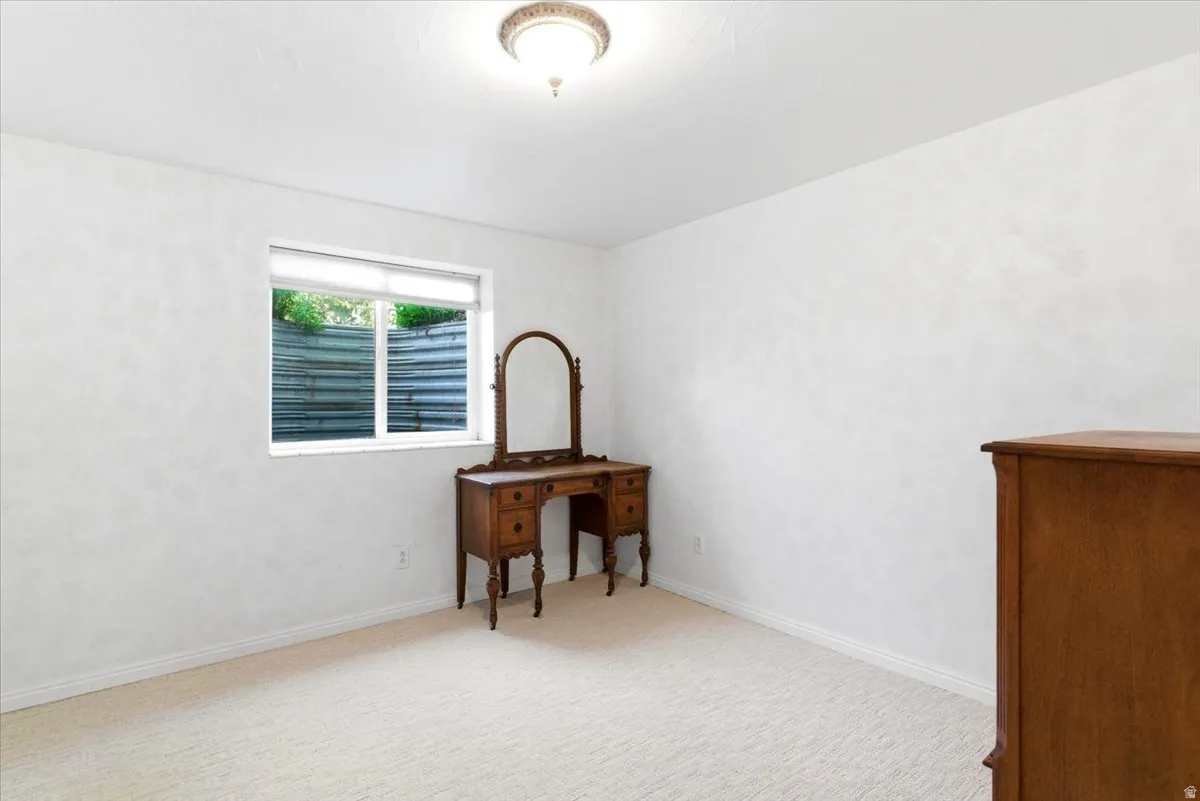 Neutral tone carpeting with white baseboards throughout