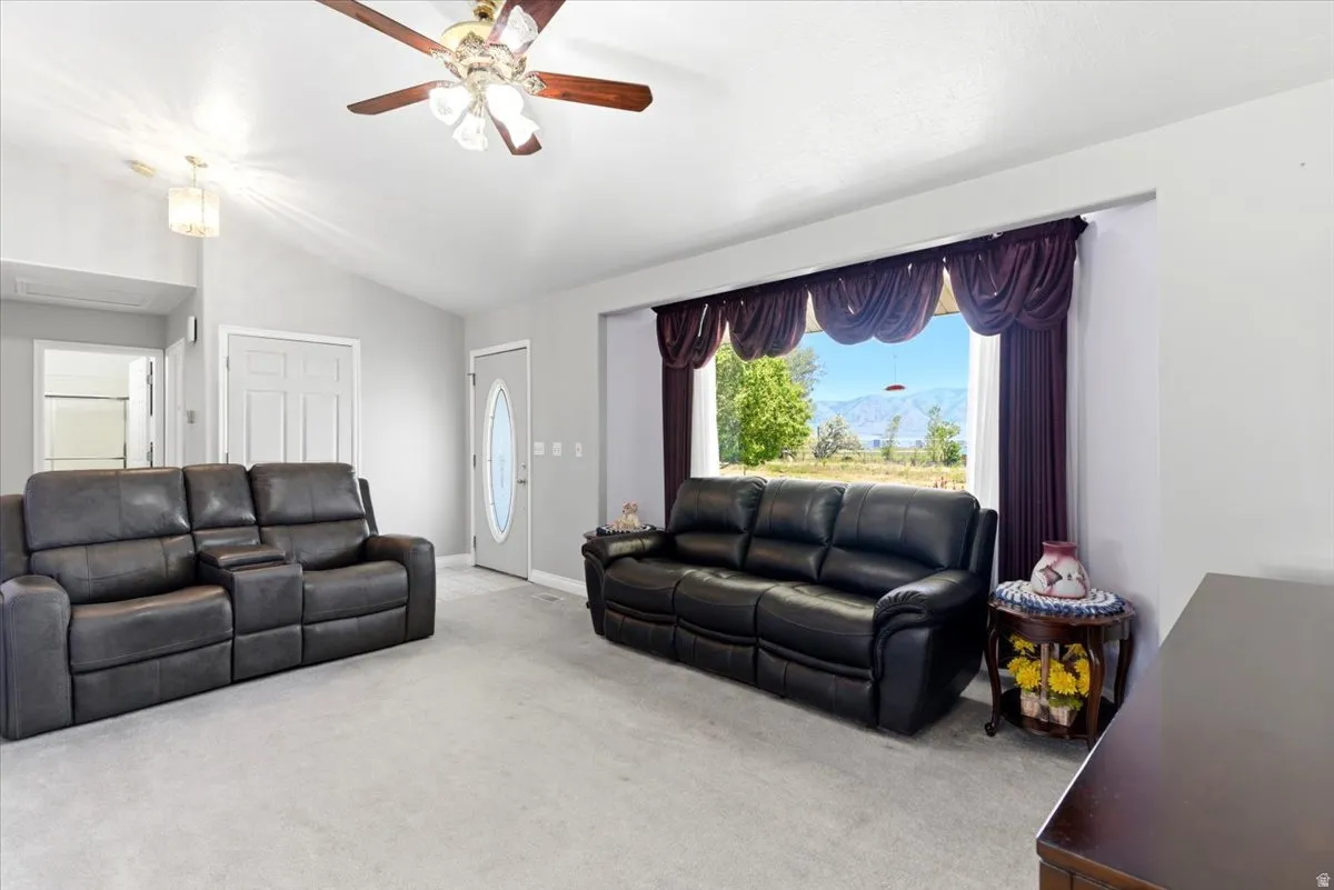 Spacious living area featuring light gray carpet flooring and neutral wall tones