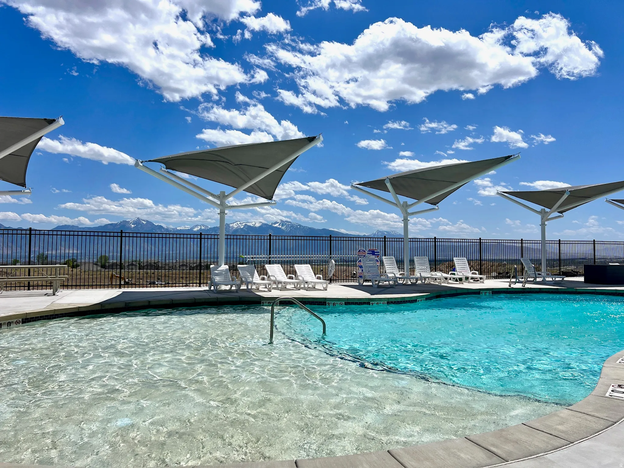 Resort-style swimming pool featuring a tanning ledge and integrated steps