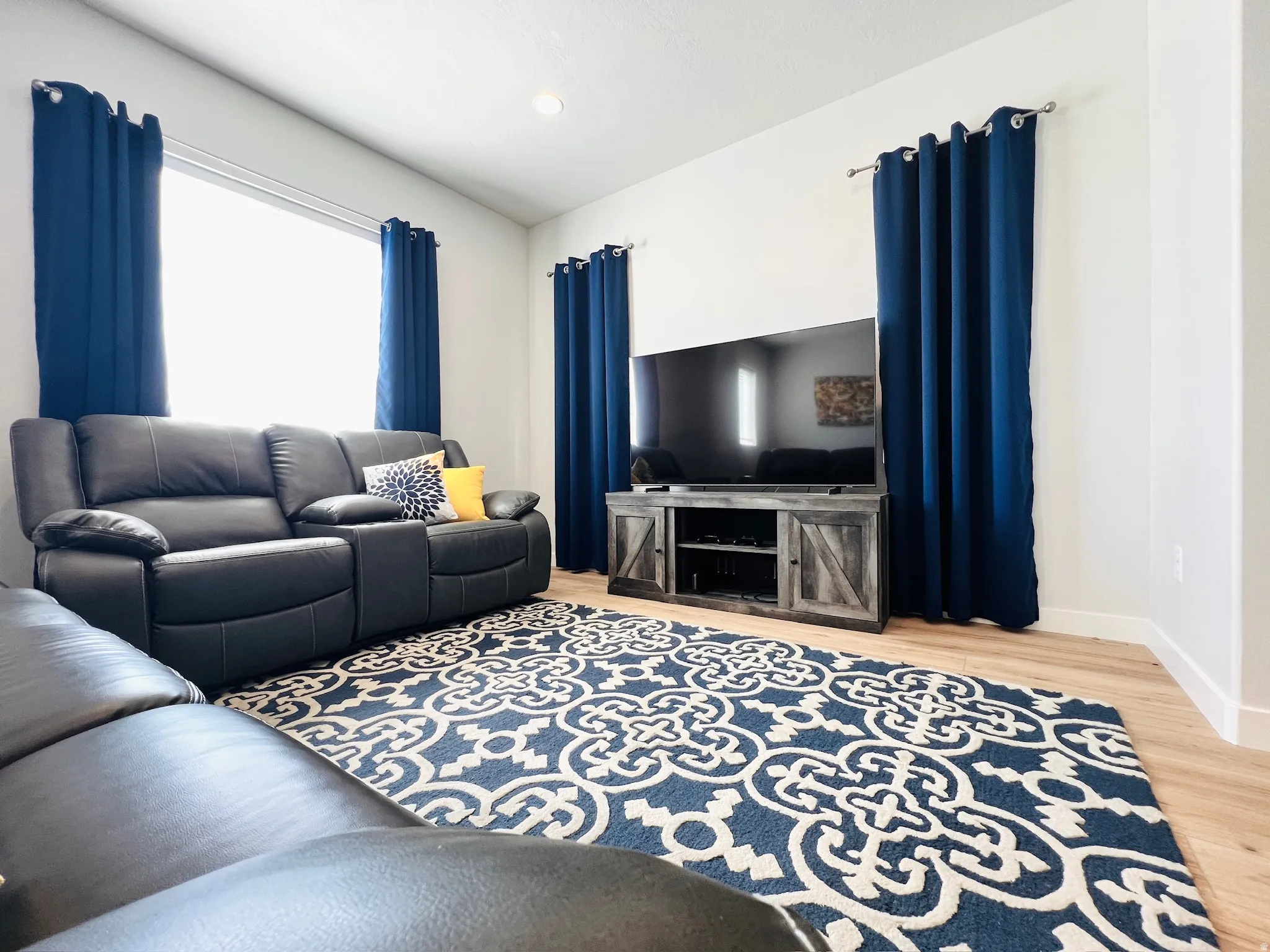 Open concept living space featuring recessed lighting, light wood-finish flooring, and white baseboards