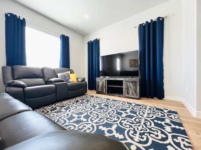 Open concept living space featuring recessed lighting, light wood-finish flooring, and white baseboards