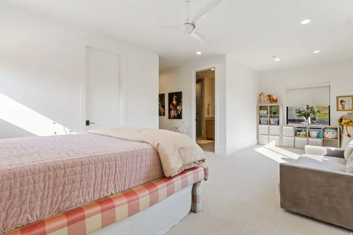 Spacious bedroom with light-colored carpet flooring and white walls