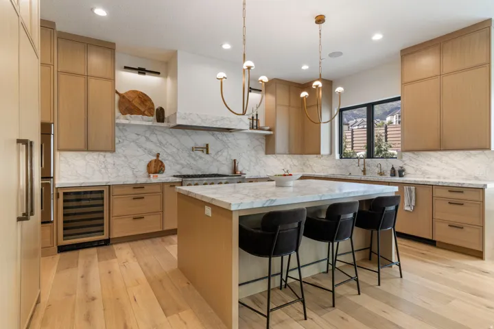 Gourmet kitchen with white oak cabinetry, Monogram appliances, and a built-white oak refrigerator