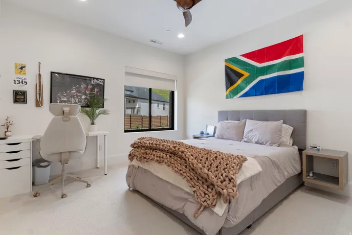 Carpeted bedroom with recessed lighting, a modern ceiling fan, and a large window featuring a roller shade