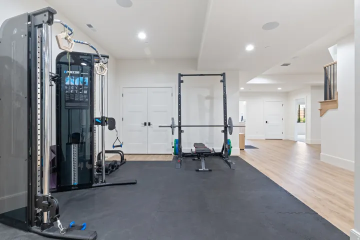Dedicated exercise area featuring rubber floor matting and recessed lighting