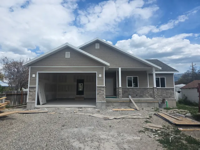 Exterior featuring horizontal siding with shake accents, a stone veneer foundation, and a covered porch entry