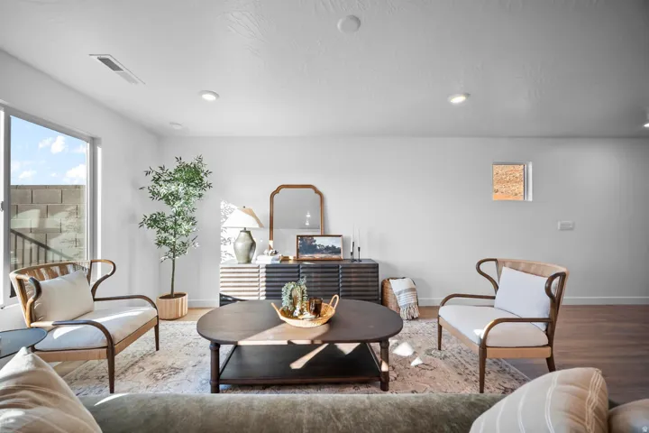 Bright living area featuring a large window, recessed lighting, and wood-finish flooring