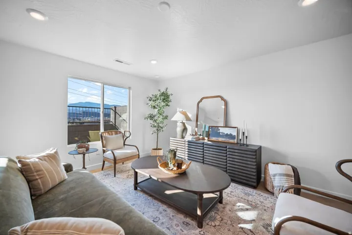 Spacious interior featuring a large window with mountain scenery, recessed ceiling lighting, and light wood-finish flooring