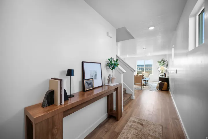 Entryway featuring wood-finish flooring, a long console table, and a staircase with carpeted treads