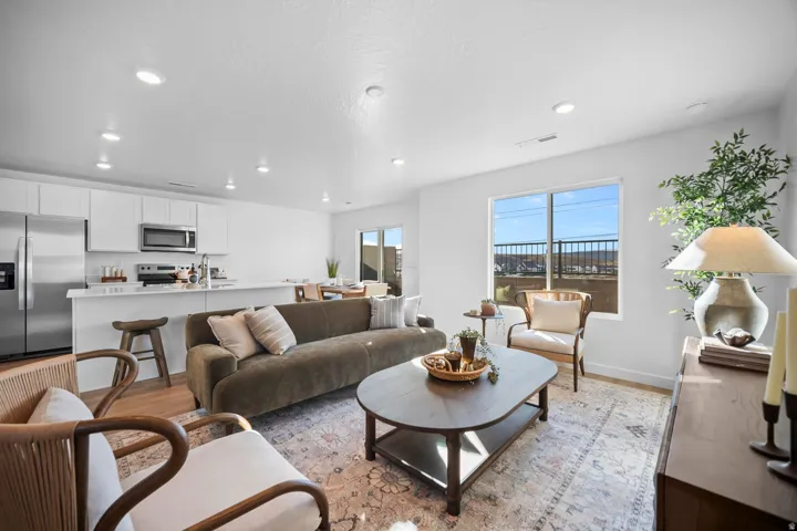 Open-concept living area with wood-finish flooring and recessed lighting