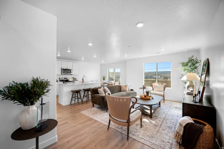 Open-concept living space featuring wood-finish flooring, recessed lighting, and large windows