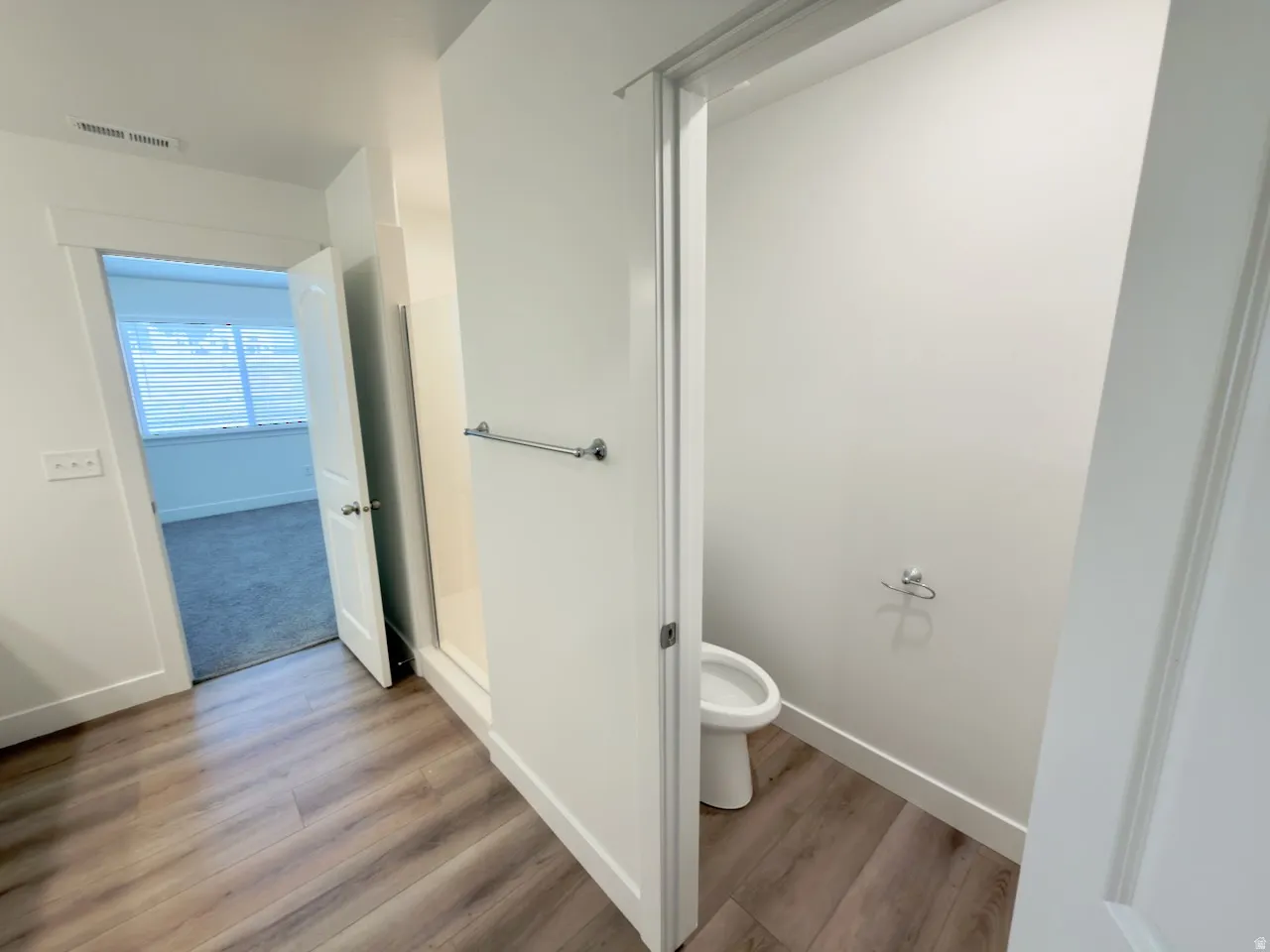 Laminate wood-finish flooring provides a durable surface throughout this bathroom area