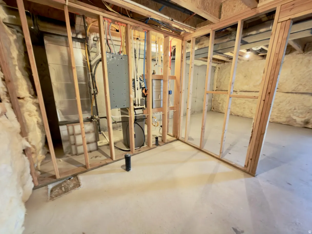Unfinished basement with concrete flooring and exposed wood framing