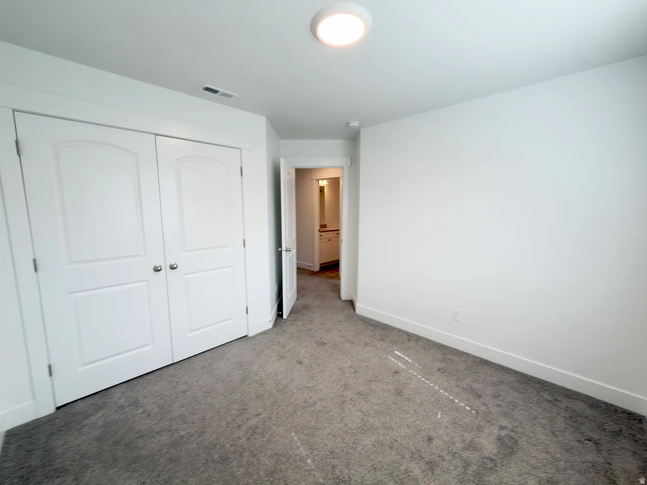 Room featuring light gray carpeting, white walls, and a flush mount ceiling light