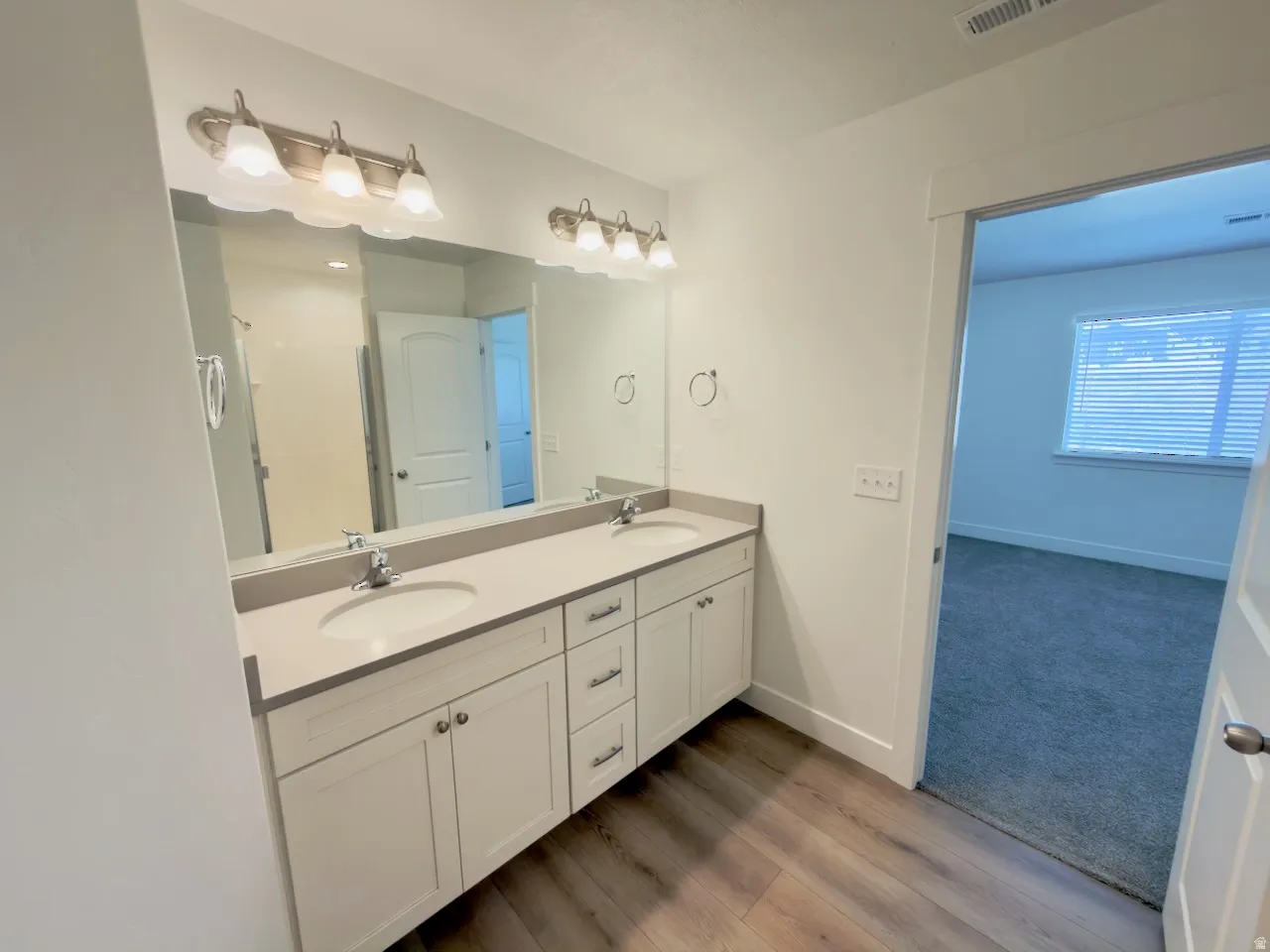 Bathroom featuring a dual vanity with light grey cabinetry and a coordinating countertop