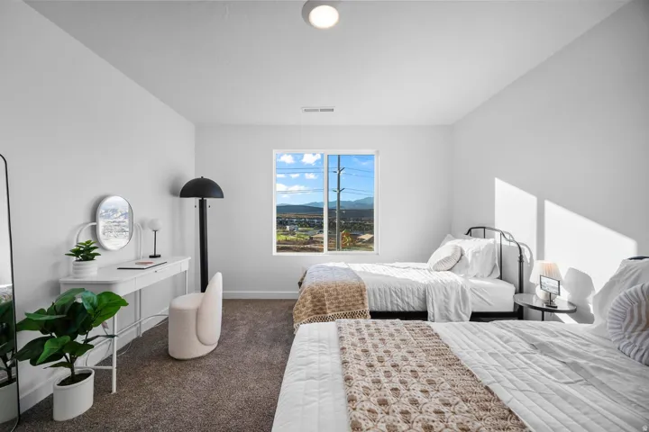 Bright room featuring neutral wall paint, a single window, and textured carpet flooring