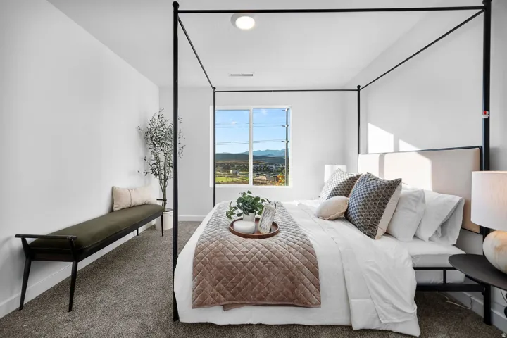 Bedroom with a large window and distant mountain scenery