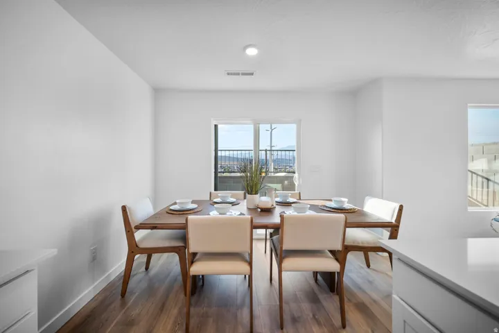 Spacious dining area featuring wood-finish flooring, a sliding glass door, and abundant natural light
