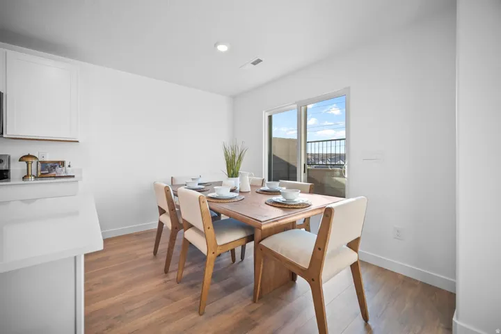 Dining area featuring wood-finish flooring, recessed lighting, and a sliding glass door providing outdoor access
