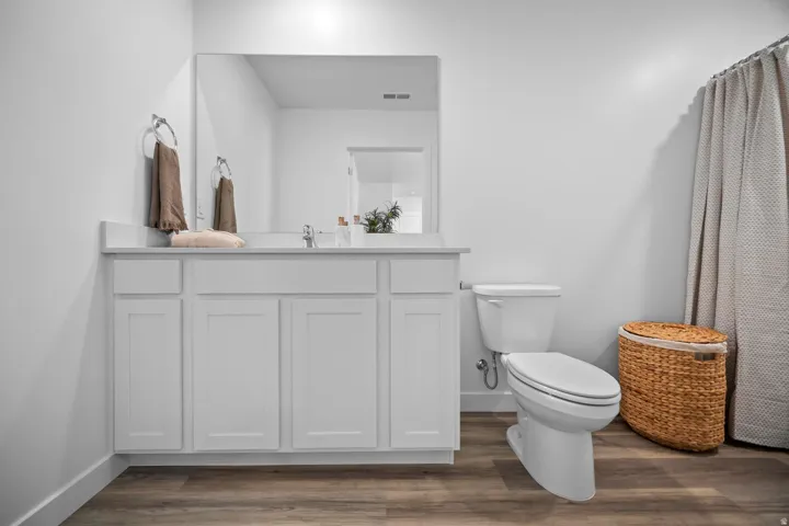 Bathroom featuring a white vanity with cabinet storage, a light-colored countertop, and a large wall-mounted mirror