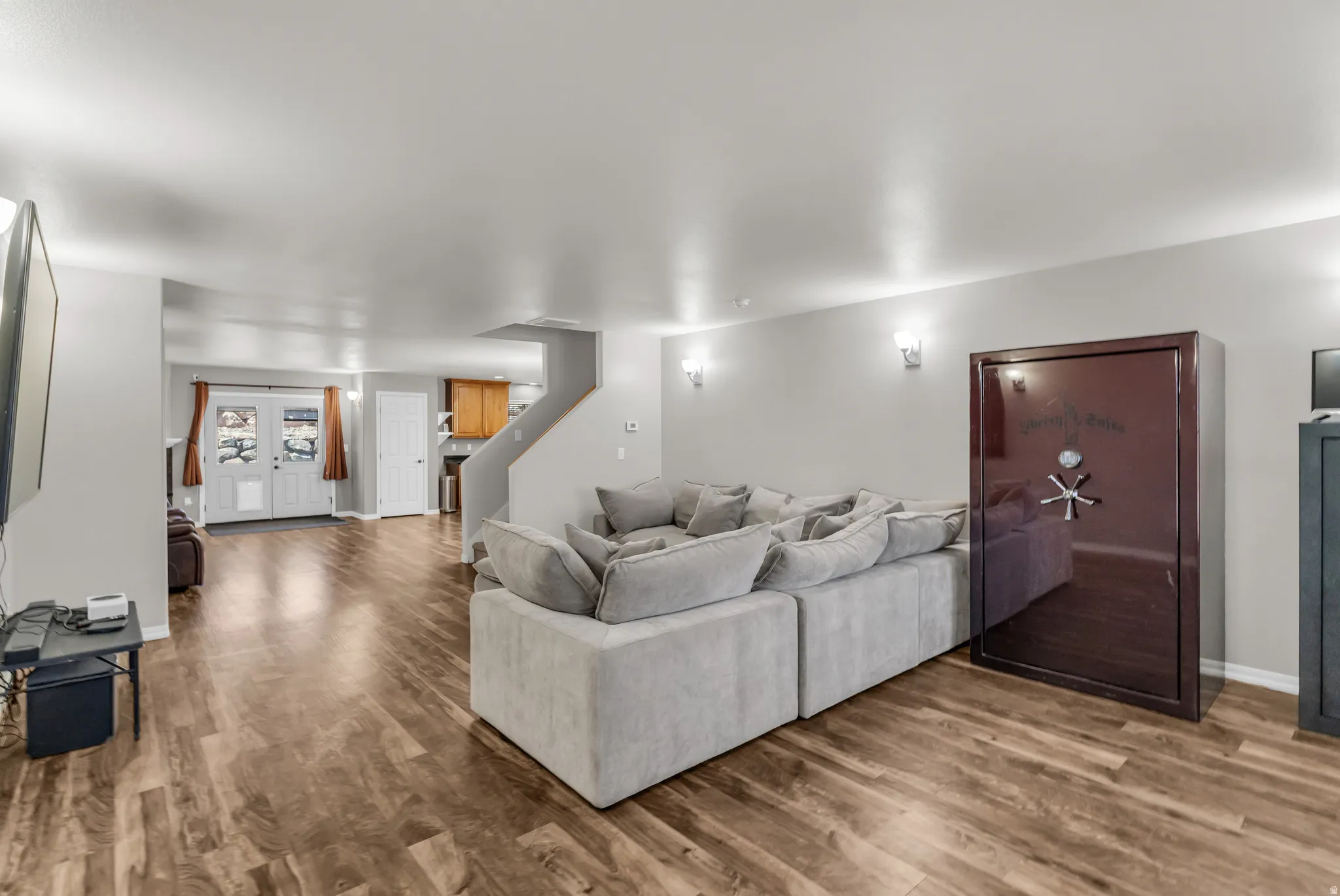 Spacious living area featuring wood-finish flooring, light grey walls, and recessed lighting