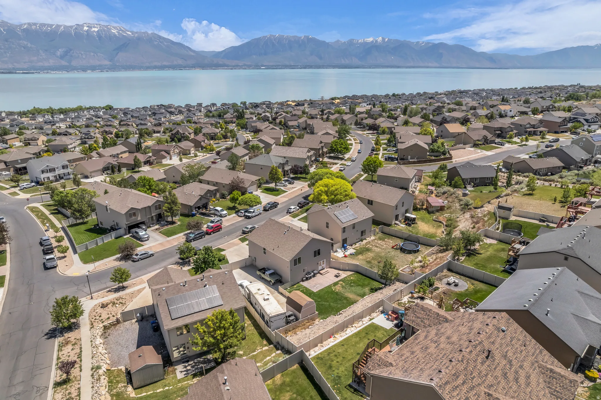 Aerial perspective showcasing a residential neighborhood with mountain and lake scenery